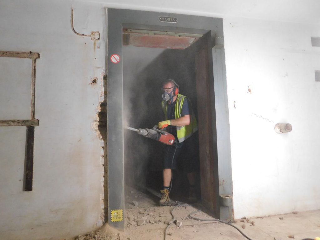 Using hydraulic drill to remove vault door